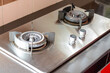© TeacherPhoto - The image shows a gas stove burner with a circular burner head and four metal windshields.