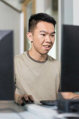 A young man sitting at a desk, focused on using a computer