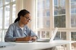 © ColorfulFlowerStudio - Focused Young Woman with Glasses Working at Desk