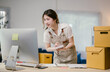© PaeGAG - Confident young asian woman entrepreneur manages online orders from her home office, focusing on sales and product delivery with ease and determination