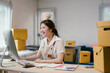 © PaeGAG - Young entrepreneur works from her cozy home office, surrounded by cardboard boxes, managing her online business with dedication and passion