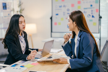 two businesswomen are having a productive meeting, analyzing charts and documents while sharing thei