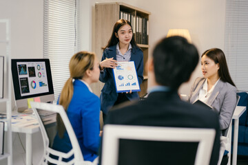 Fototapete - Confident businesswoman presents marketing data to diverse team in office meeting, fostering collaboration and teamwork