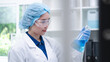 © Supapich - Woman scientist chemist holding laboratory blue liquid beaker test tube equipment for discovery analysis science chemical medicine development experiment technology biotechnology development