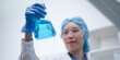 © Supapich - Woman scientist chemist holding laboratory blue liquid beaker test tube equipment for discovery analysis science chemical medicine development experiment technology biotechnology development