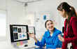 © Parichat - Two young businesswomen are discussing about work in the office, one of them is pointing at charts on a computer screen