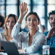 © KerXing - Business associates in a training session, one participant raising a hand to ask for guidance.