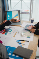 Business Professionals Analyzing Data:  A close-up image of two business professionals collaborating over a desk littered with financial reports and charts.