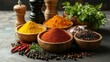 © savittree - Assorted colorful spices in wooden bowls on a rustic table, surrounded by a salt shaker, pepper mill, and fresh herbs, creating a vibrant kitchen scene.
