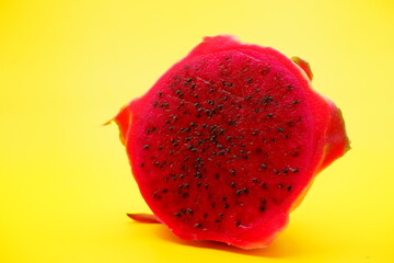 half piece of dragon fruit isolated on yellow background