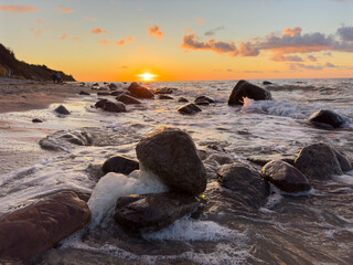 sunset on the beach with rocks on the baltic sea, isalnd Rügen in Germany Cap Arkona