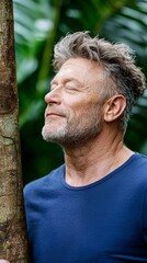 Man hugging green tree in forest, embracing tree trunk with hands. Giving hug to old tree - concept of nature love, sustainable development and environment protection