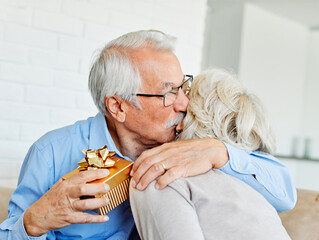 Wall Mural - gift woman man couple happy love happiness present kiss romantic smiling together box wife husband e