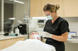 © Erik González - A woman in a black scrub suit is performing a facial on a woman