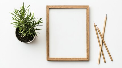 A chic minimalist composition with a wooden frame, green potted plant, and two pencils neatly placed on a white background, allowing for ample copy space on one side.