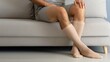 © hisilly - Compression Stockings for Varicose Veins and Thrombosis Recovery: Unrecognizable Man Resting on Sofa with Medical Anti-Varicose and Anti-Thrombotic Sleeve Socks