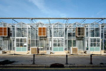 Modern Industrial Greenhouse Exterior with Air Conditioning Units under a Clear Blue Sky