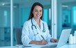 © Thierry - Medical professional writing at her desk, smiling in a clinic.