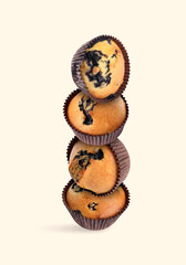 Poster - Stacked tasty blueberry muffins on beige background