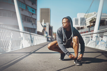 Canvas Print - Thinking, runner and tie shoes in city for cardio training, running exercise or fitness workout. Ideas, bridge and African athlete on ground ready to start jog, race or marathon practice in footwear