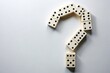 © Sarayuth - A unique domino shape resembling a question mark on a plain background, at a tilted angle