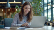 © mattegg - Smiling Woman Working on Laptop at Desk in Modern Office