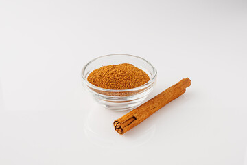 Closeup of Aromatic Ground Cinnamon and Sticks on a White Background