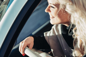 Smiling woman driving car looking around for directions