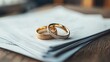 © Pannin - Wedding rings on a stack of divorce paperwork, symbolizing the finality of a relationship ending legally and emotionally