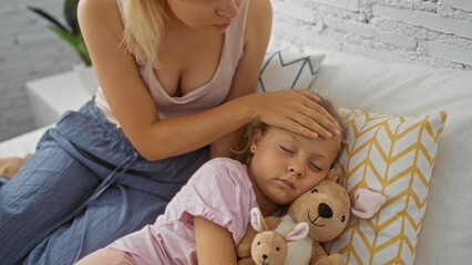 Woman caring for sick daughter in cozy bedroom, showing affection and comfort with child lying in bed holding a stuffed toy while mother checks her forehead for fever