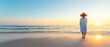 © DOUGLAS - young woman stands on beach, embracing freedom of sea as sun sets on horizon. serene atmosphere evokes sense of peace and tranquility