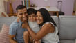 © Krakenimages.com - Happy family at home featuring a man, woman, and child sitting together on a couch in a cozy living room