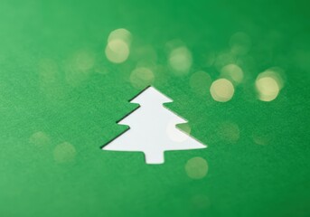 Wall Mural - Christmas tree shape cut out of green paper with a white background creating a festive atmosphere