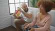 © Krakenimages.com - A joyful interracial couple enjoy gaming together in a cozy urban living room.