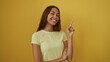 © Krakenimages.com - Beautiful african american woman smiling and pointing with finger over isolated yellow background