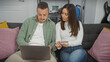 © Krakenimages.com - Couple reviews finances with credit card and laptop at home, showcasing teamwork and planning.