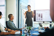 © C.Arcurs/peopleimages.com - Woman, boardroom and statistics on screen for presentation, report and feedback as finance analyst. Business, clients and people in meeting for financial solution, company growth and results