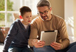© CineLens2024/peopleimages.com - Home, father and boy with tablet, love and bonding together with happiness, connection and social media. Single parent, dad or son with tech, talk or digital app with internet, website info or relax