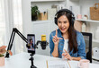 © Summit Art Creations - Host channel Asian influencer talking in broadcast wearing headsets on social media live on smartphone recording online, greeting listeners with coaching life or business at modern studio. Stratagem.