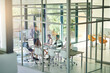 © C.Arcurs/peopleimages.com - Teamwork, glass and business people in meeting, presentation or planning for project, feedback and results. Speaker, corporate professional or employees in modern office, coaching or talk with mentor