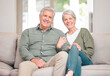 © CineLens2024/peopleimages.com - Portrait, mature couple and happy on sofa in living room at home for bonding, support and care in Germany. People, relationship and smile with confidence on couch for retirement, rest and relax