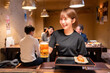 © maroke - ビールを提供する居酒屋の女性スタッフ