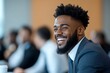 © Odin AI - A confident businessman with a bright smile engages at a corporate conference, his focus directed at the audience who's blurred, conveying professionalism and connectivity.