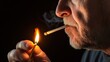 © LifeMedia - An elderly man, captured in close-up, lights his cigarette with a match that illuminates his thoughtful expression, emphasizing an introspective nighttime setting.