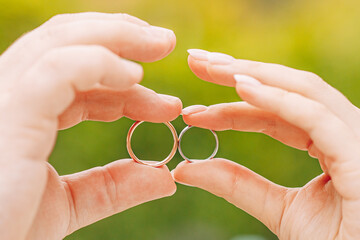 Newlyweds exchange rings, groom puts the ring on the bride's hand.