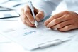 © Odin AI - Close-up of hands holding a pen, analyzing graphs and data on white paper, symbolizing analysis, finance, and strategic planning in a professional setting.