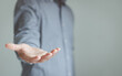 © THAWEERAT - The man is standing and shows an outstretched hand with an open palm. Businessman showing empty hand and presenting with hand empty copy space. Open hand, Holding, giving, showing, presenting concept.