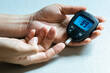 © Photo Sesaon - hand of people check diabetes and high blood glucose monitor with digital pressure gauge. Healthcare and Medical concept