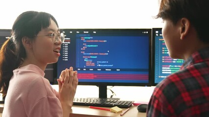 Slow motion back end software developer engineer for computer programming working together on debugging writing computing code, solving complex algorithms display on monitor in office. Burgeoning