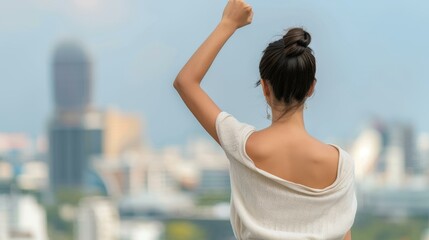 A powerful moment as a woman raises her fist, symbolizing strength and unity against the backdrop of a vibrant city skyline.